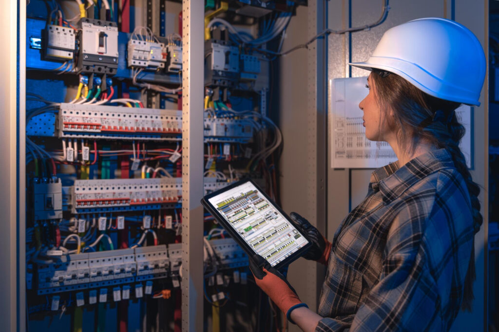 painéis elétricos industriais certificados em inspeção técnica com engenheira analisando sistema
